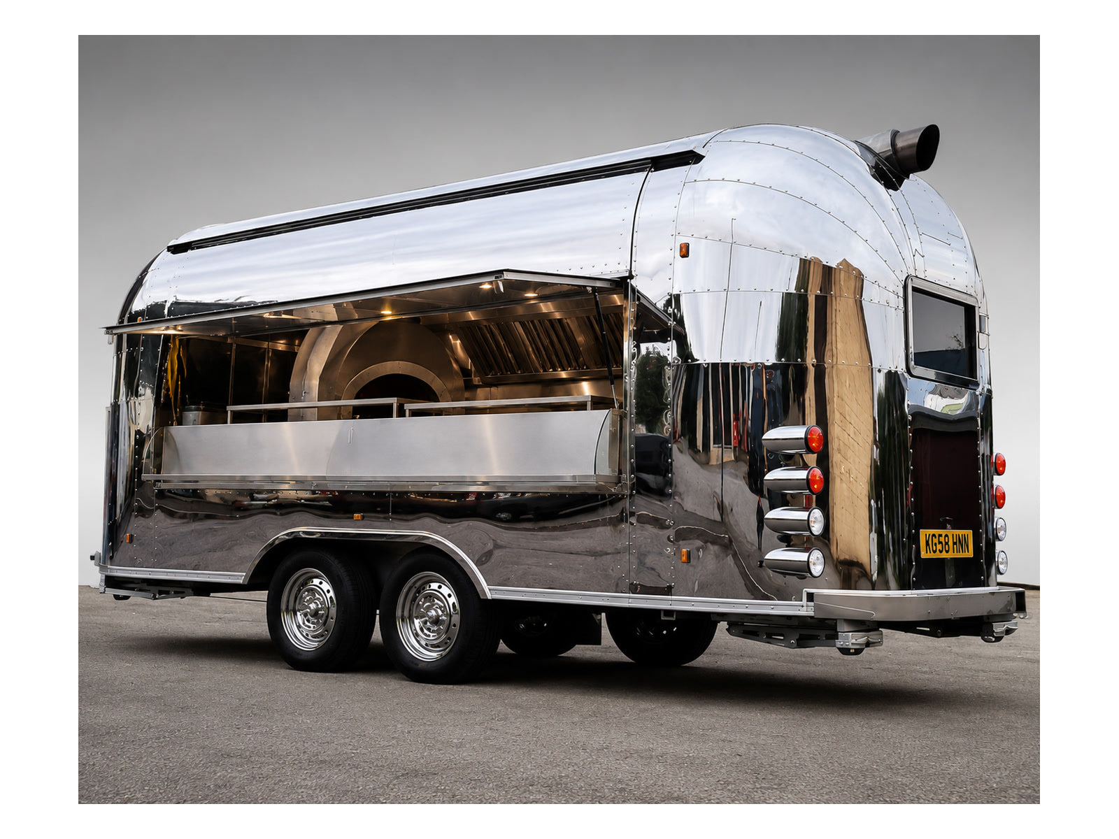 Polished stainless Airstream style food trailer with serving hatch and catering kitchen